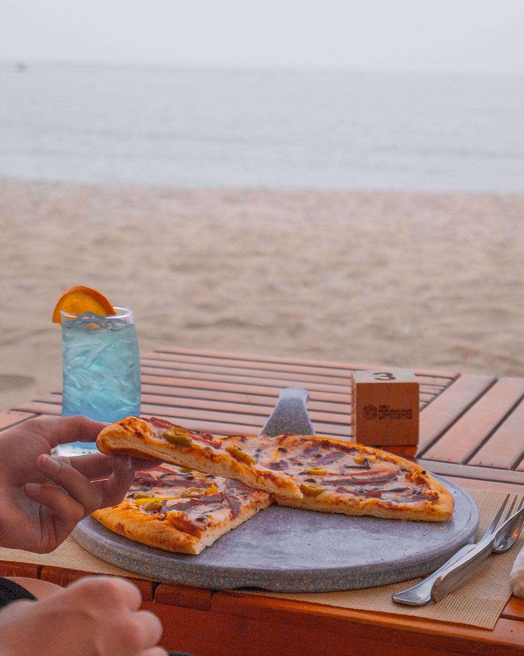 Wood-fired pizza on a sunlit deck